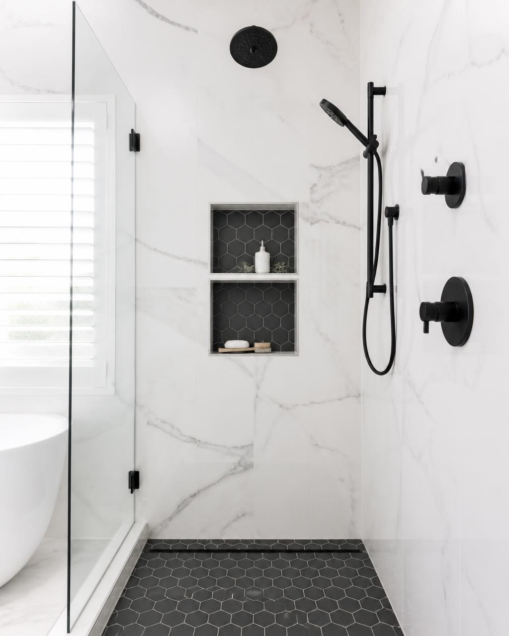 Finished walk-in tiled shower with custom niche and matte black fixtures